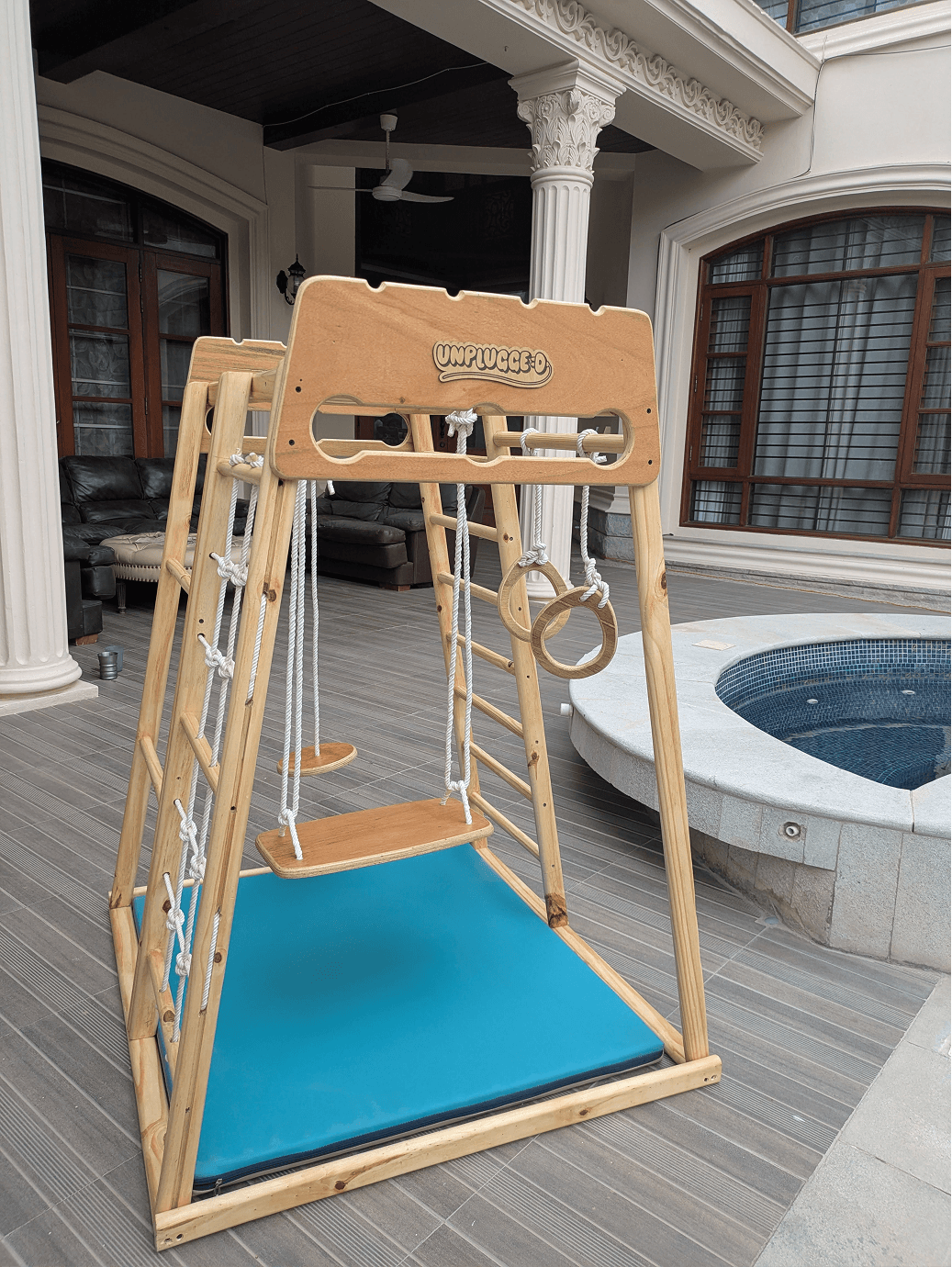Wooden jungle gym with swing, gymnastic rings in an outdoor area