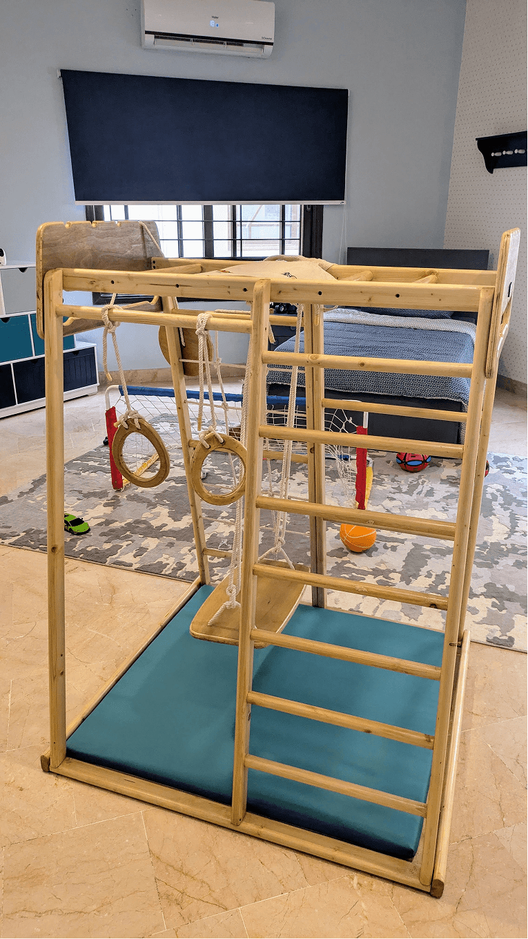 Wooden jungle gym with gymnastic rings, ladder, swing and monkey bar