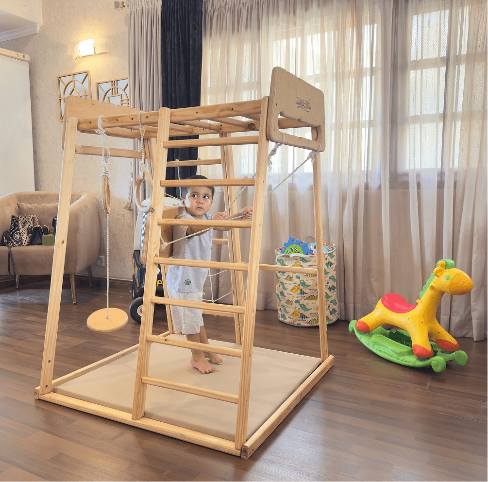 Child playing on a wooden jungle gym in a living room.